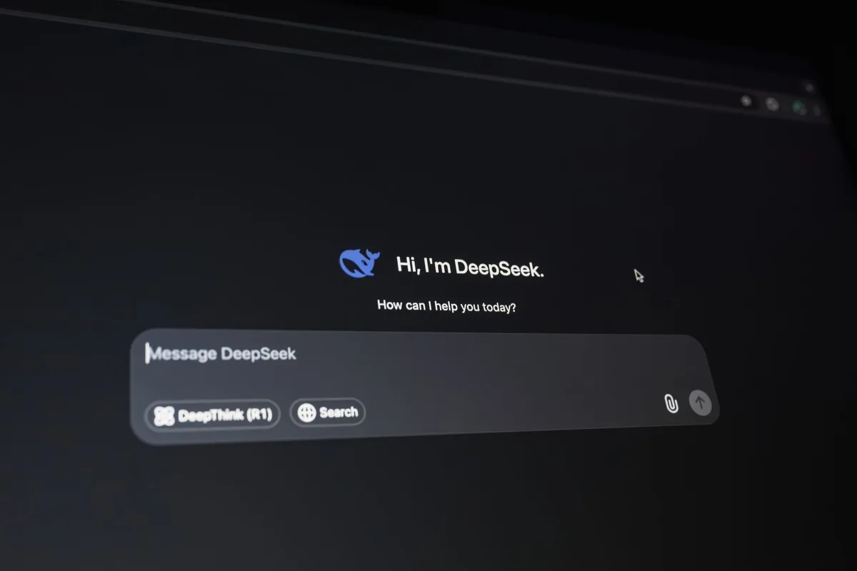 Manos anónimas escribiendo en un teclado con interfaz de chat visible en pantalla de laptop
