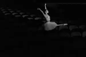 Estudiante ensayando en escena teatral escolar con luces de escenario