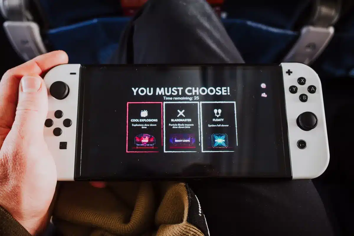 A glowing Netflix interface on a dark screen displaying a gaming title card, with a controller silhouette in the foreground and neon blue light reflecting off the device, suggesting anticipation and streaming access