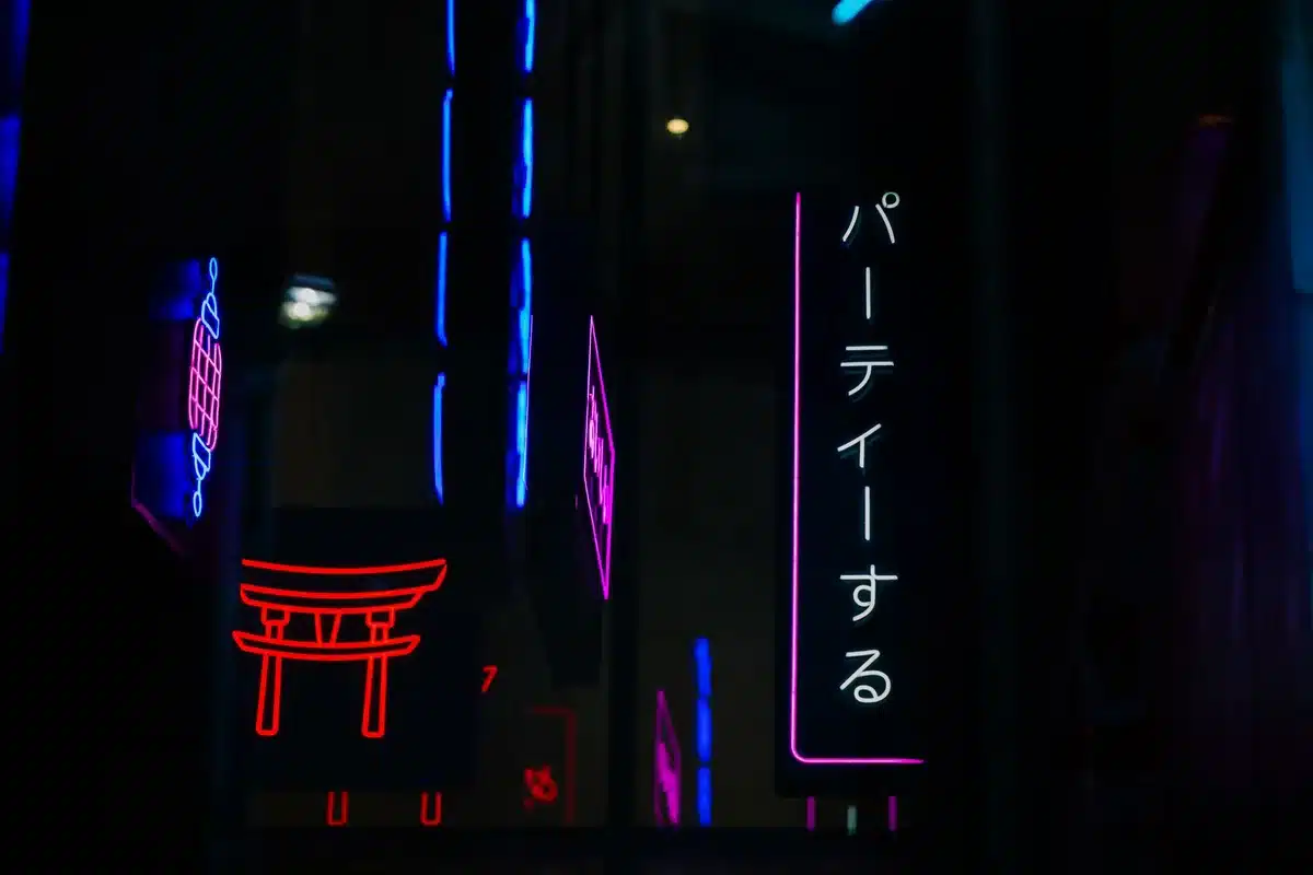 A split-screen view of two anonymous silhouettes facing each other in a neon-lit urban environment, one side warm orange and the other cool blue, representing the dual protagonists and their contrasting roles