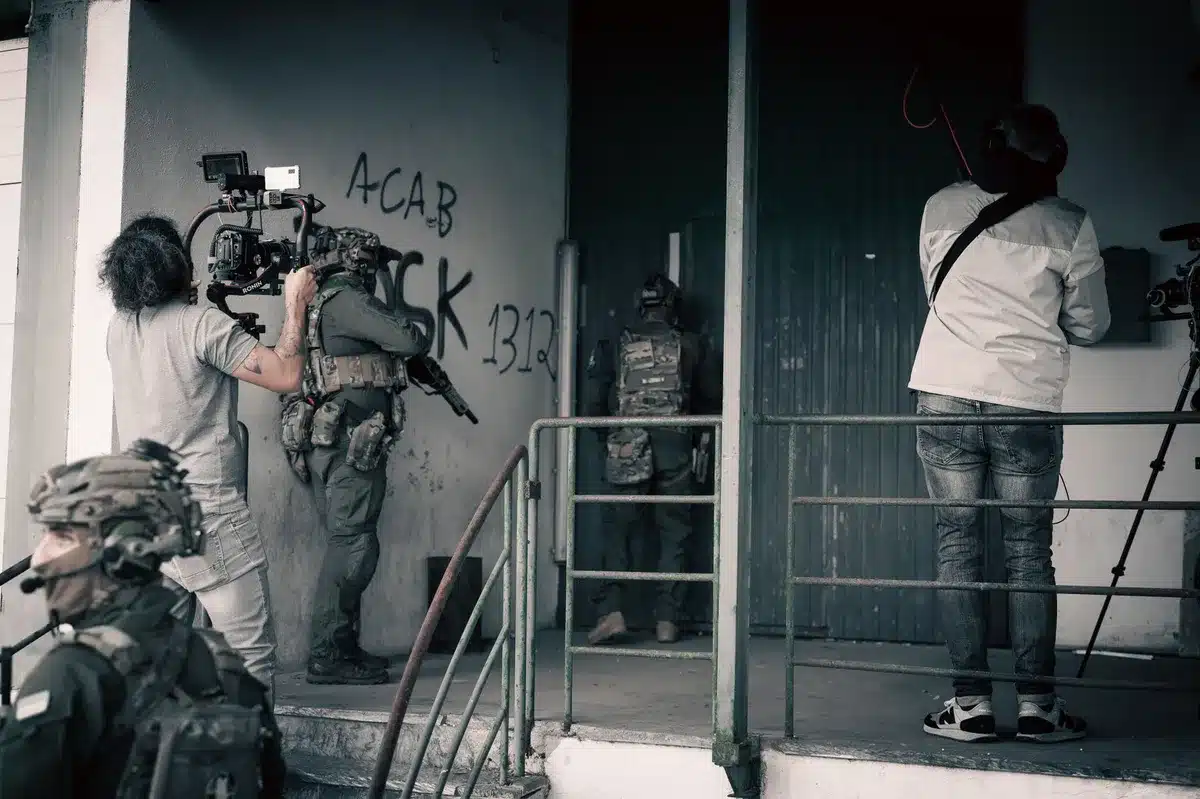 Escena de producción cinematográfica de horror con equipo técnico en set oscuro y atmosférico.