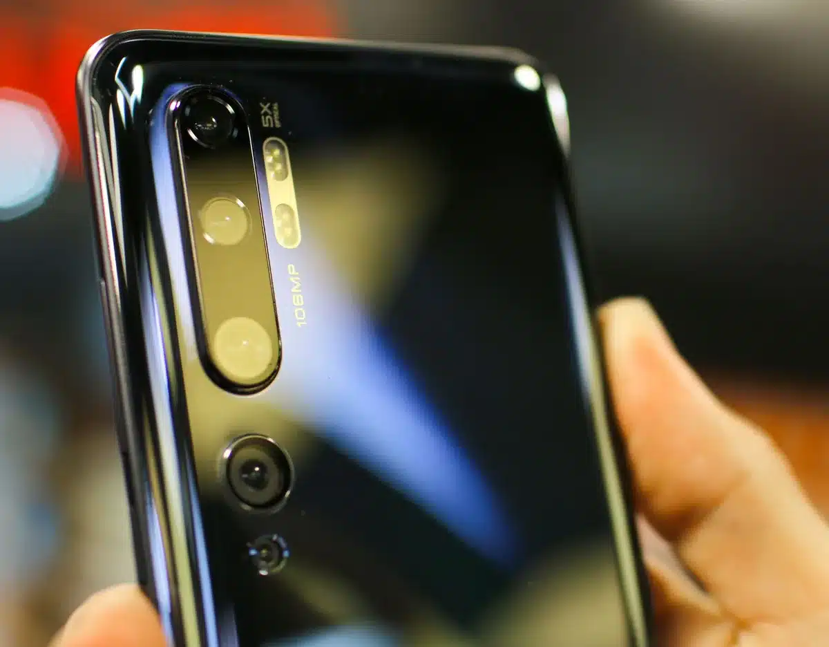 Smartphone camera system with triple lenses arranged on the back, showing advanced optics and sensor technology, professional photography setup aesthetic