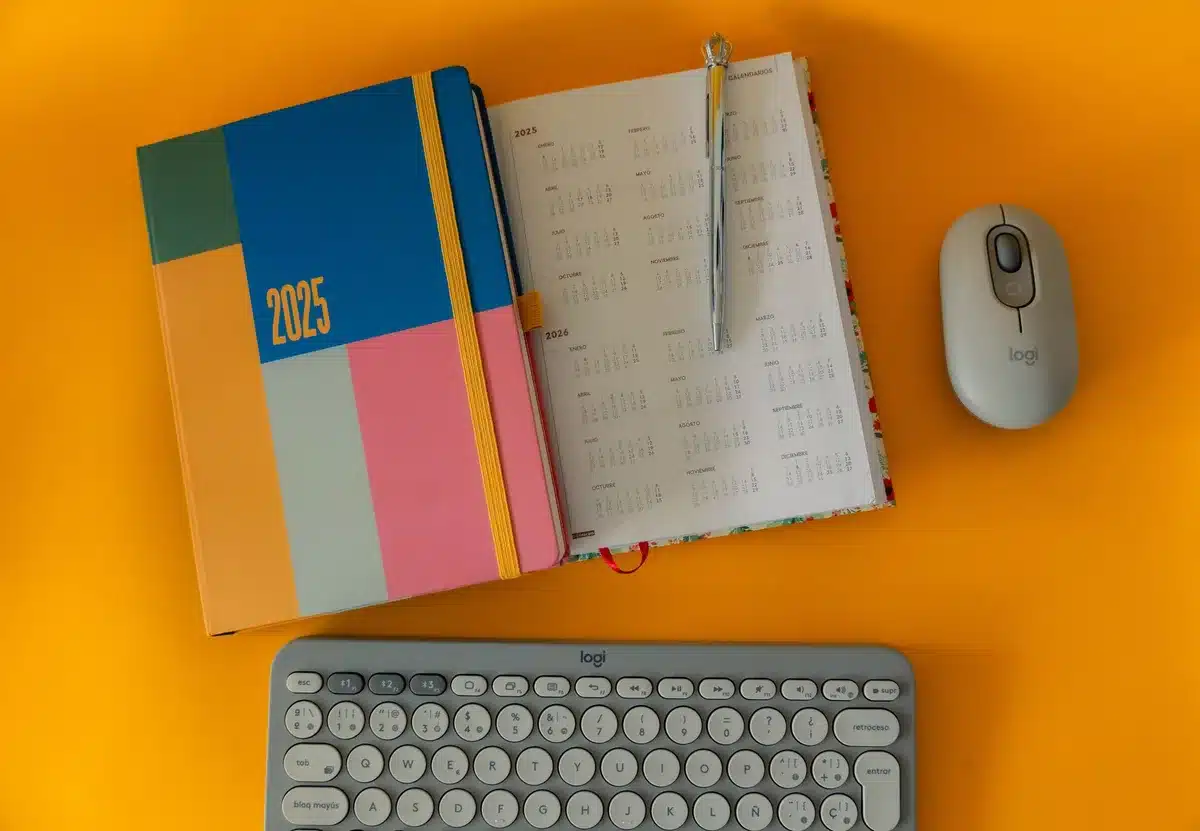 A smartphone resting on a desk next to a calendar showing years ahead, symbolizing long-term software support and device longevity.
