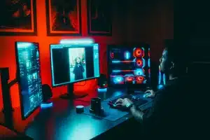 Espacio de trabajo de desarrollador de videojuegos con monitores, equipos de consola y documentos de proyecto