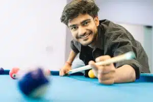 Jugador de snooker en concentración sobre la mesa con taco en mano bajo iluminación teatral