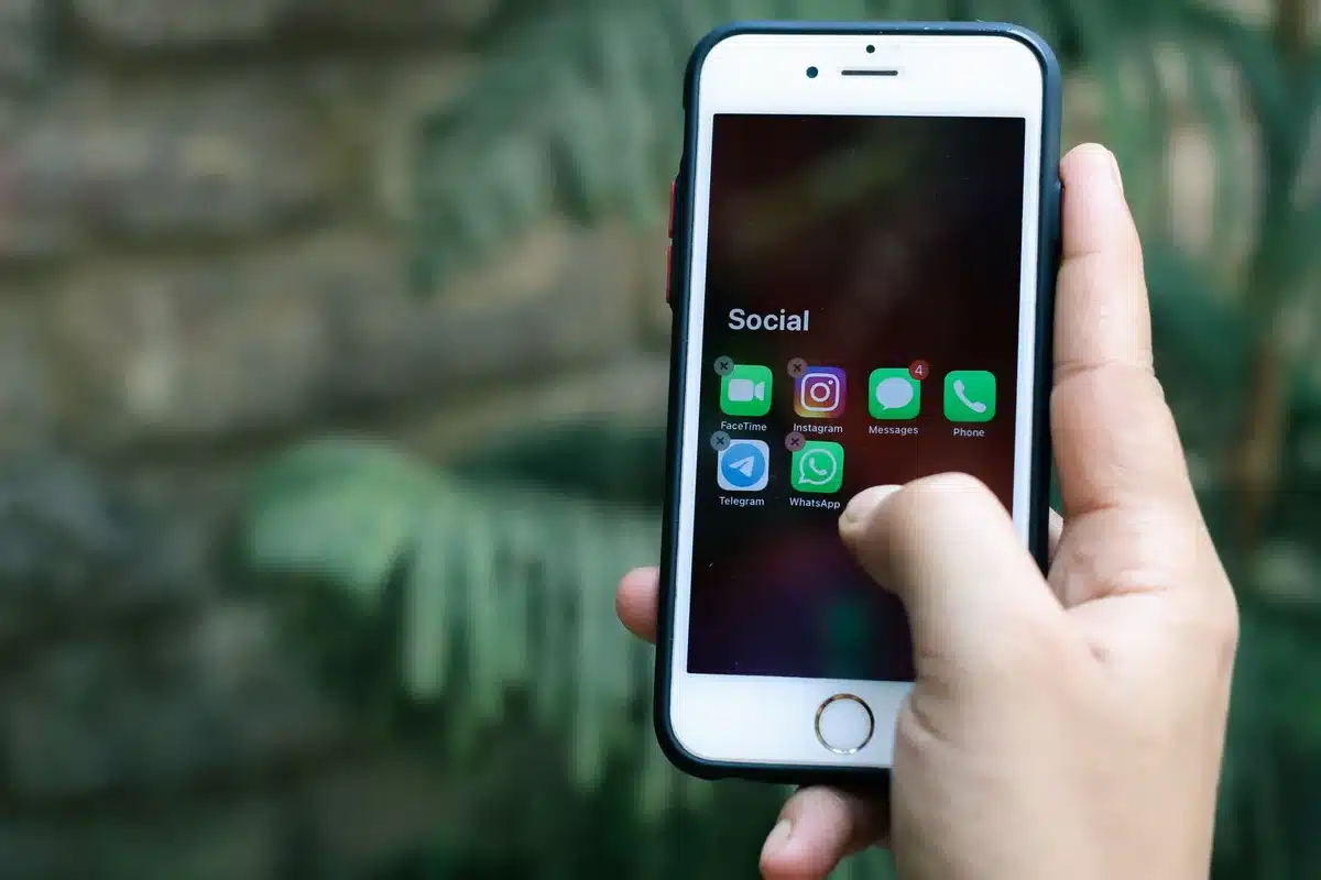 Smartphone screen showing WhatsApp location interface with search bar and map pin, user selecting a destination address from search results