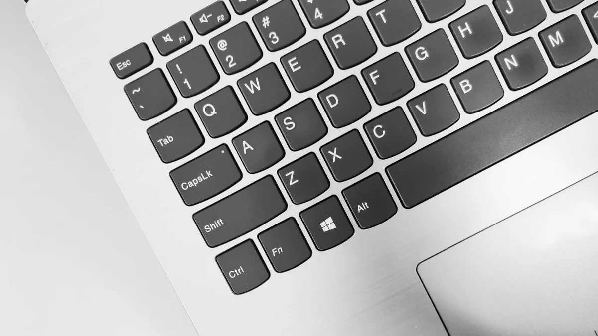 A laptop keyboard with a glowing blue Windows logo key, representing Windows 11 system optimization and performance improvements