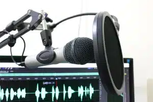Micrófono de estudio, auriculares y páginas de guion sobre una mesa en un estudio de doblaje