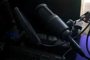 Estudio de grabación con micrófono y mesa de sonido, figuras en sombra