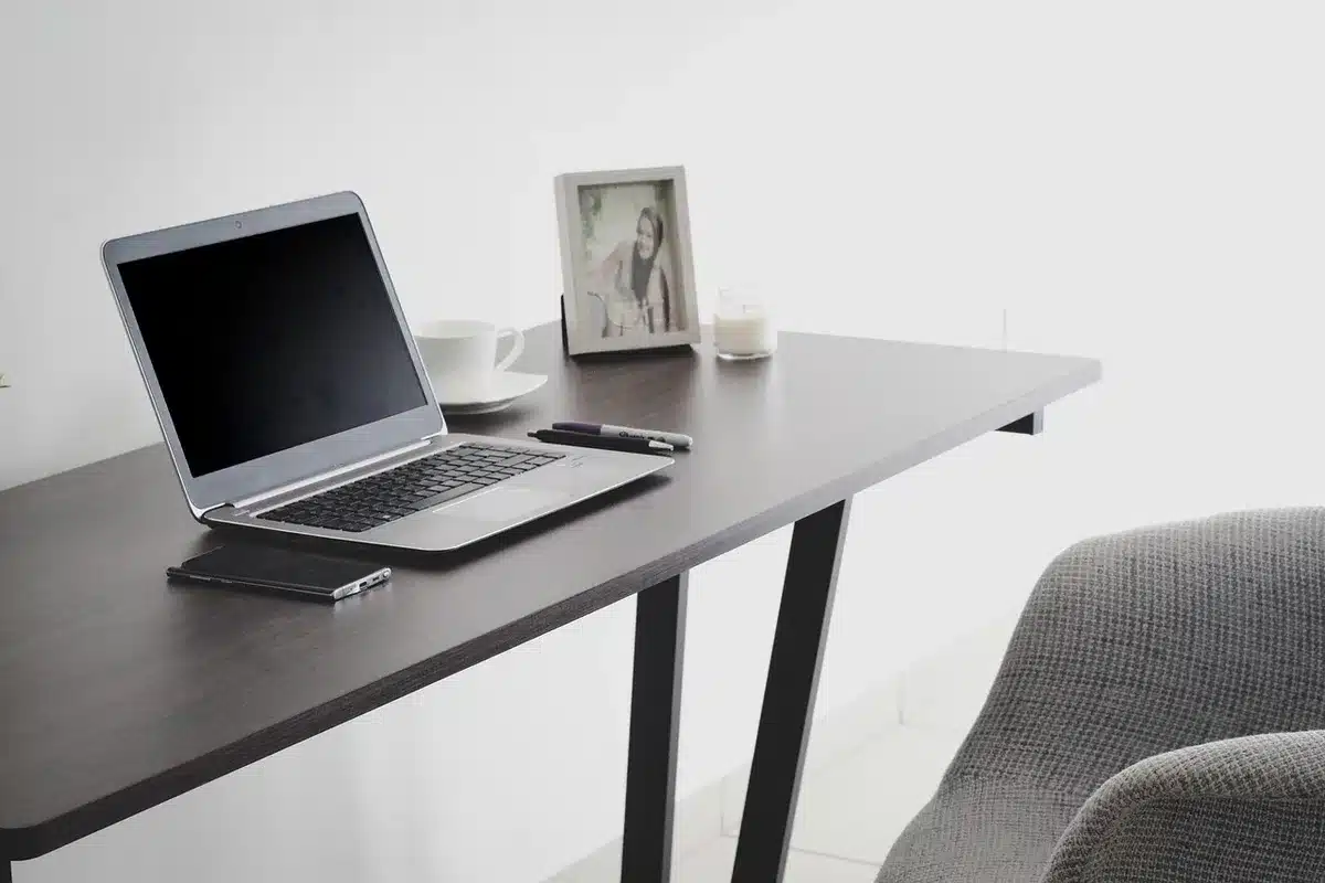 close-up of heavy-duty black metal desk frame showing lifting mechanism and cable management tray, no logos