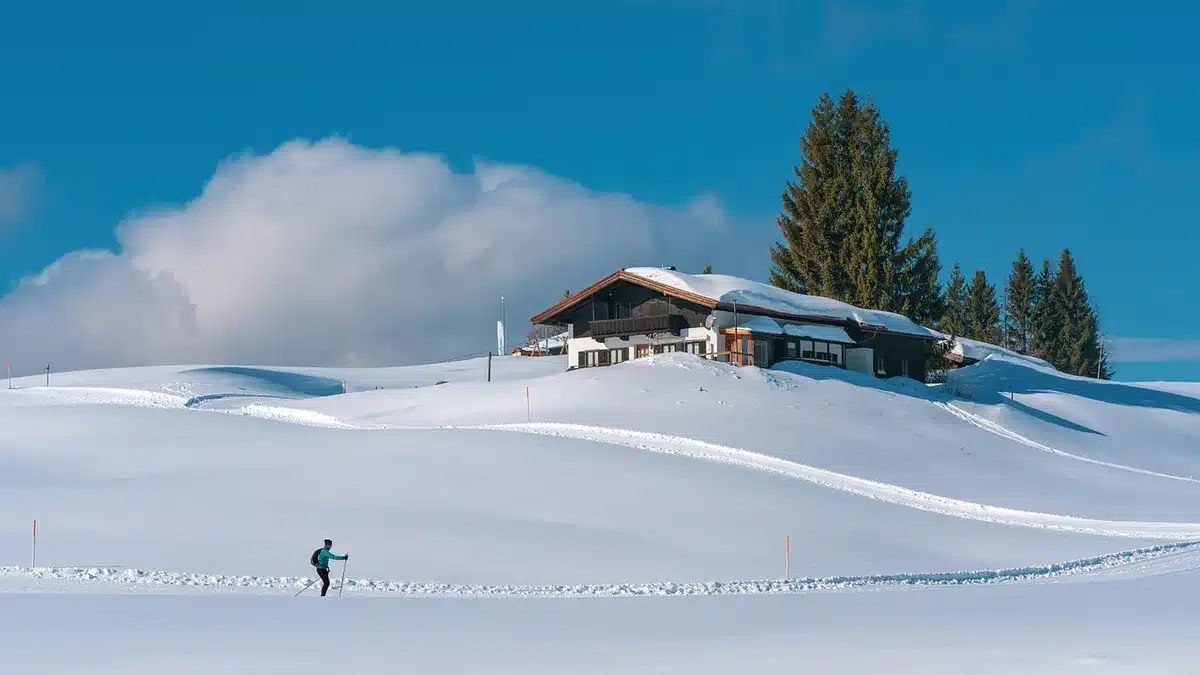 Anonymous skier silhouette in indoor ski centre, blurred background, watch on wrist visible but unbranded, motion blur suggesting slope action