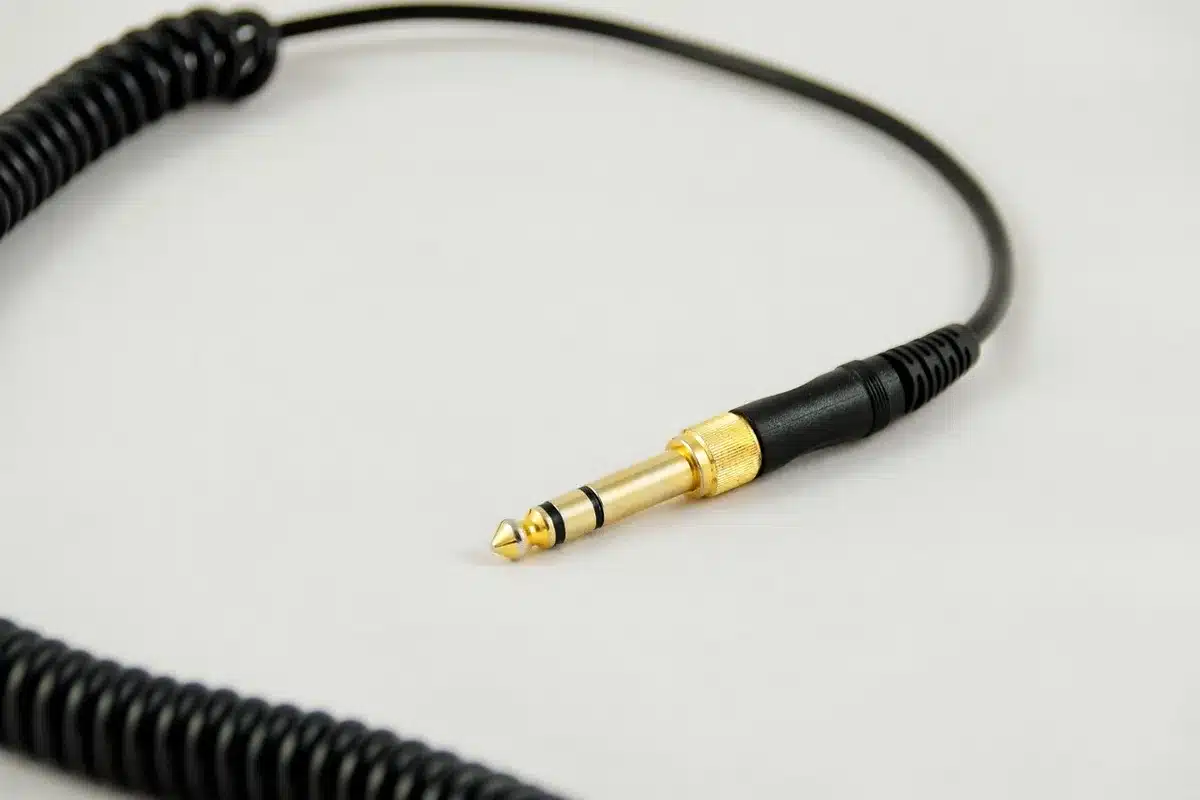 An anonymous hand plugging an unbranded braided cable into a compact wall charger on a bedside table, simple domestic setting, soft evening light