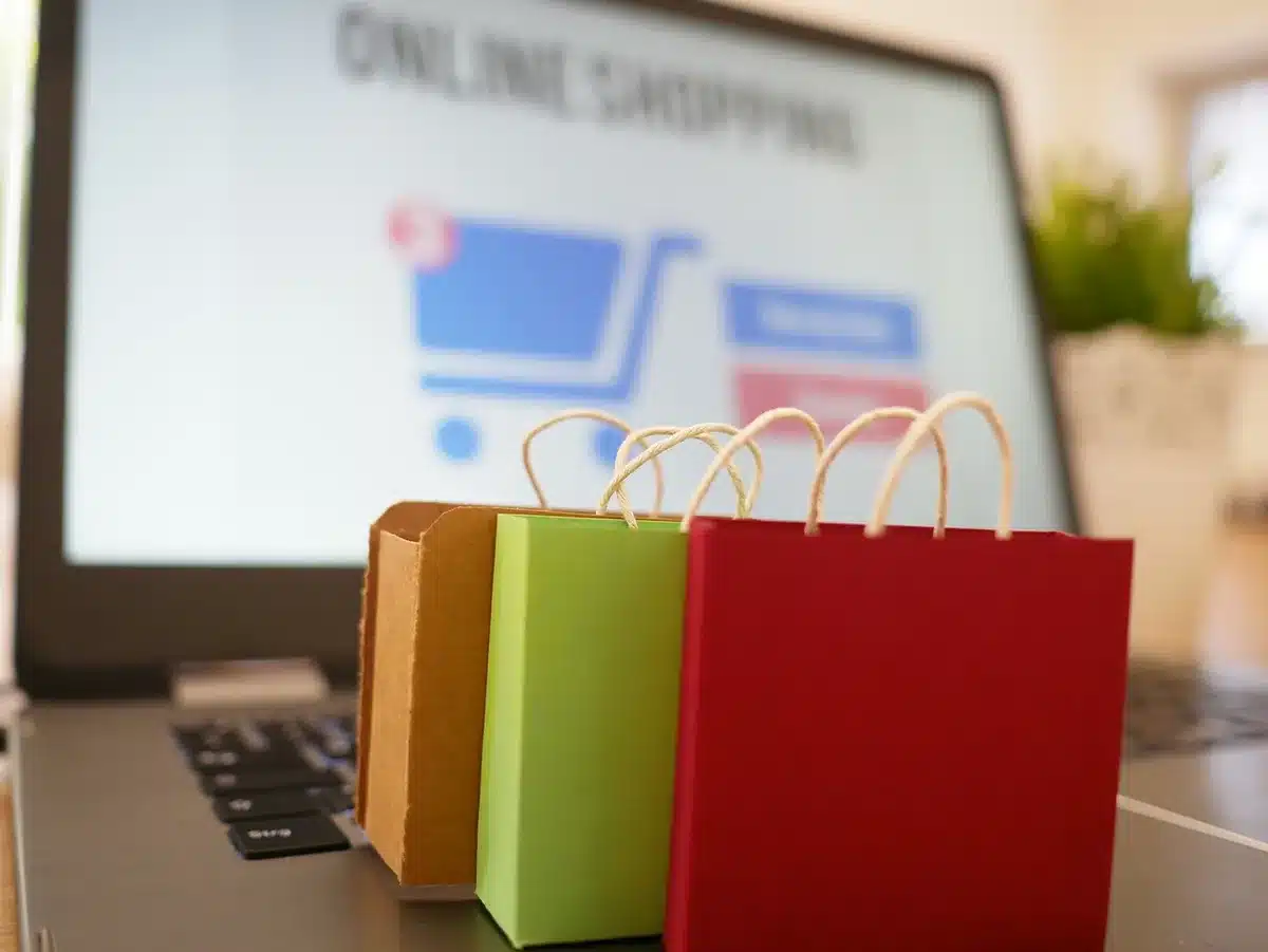 Close-up of an anonymous person’s hands hovering over a laptop keyboard with an online shop page visible but unreadable