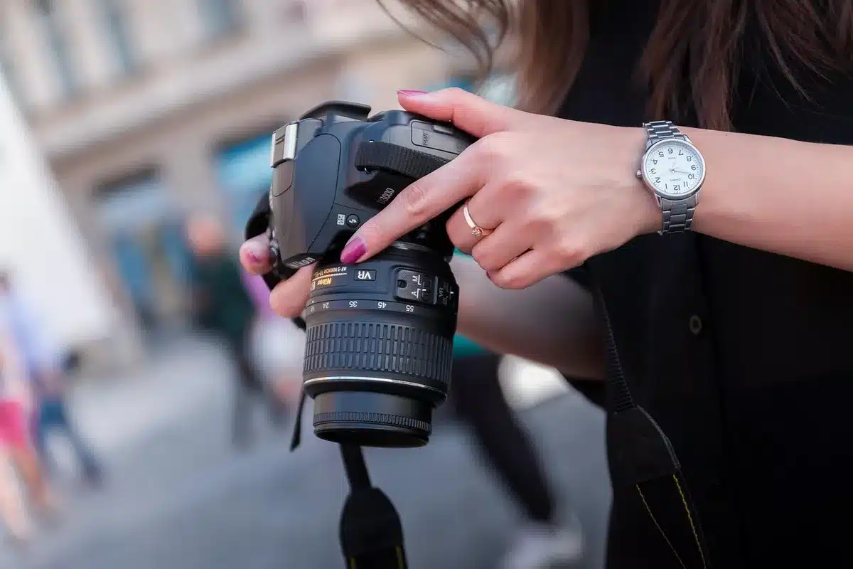 An anonymous person adjusting an unbranded fitness watch strap on their wrist, blurred city background, no identifiable features