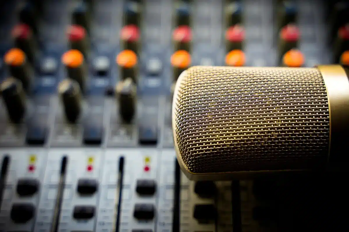 Dos presentadores en un estudio de podcast revisando datos y estadísticas en pantalla