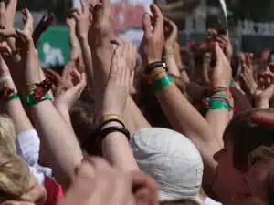 Audiencia anónima aplaudiendo frente a un escenario con trofeos