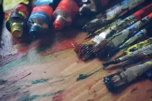 Manos anónimas revisando bocetos y paletas de color en un estudio de animación