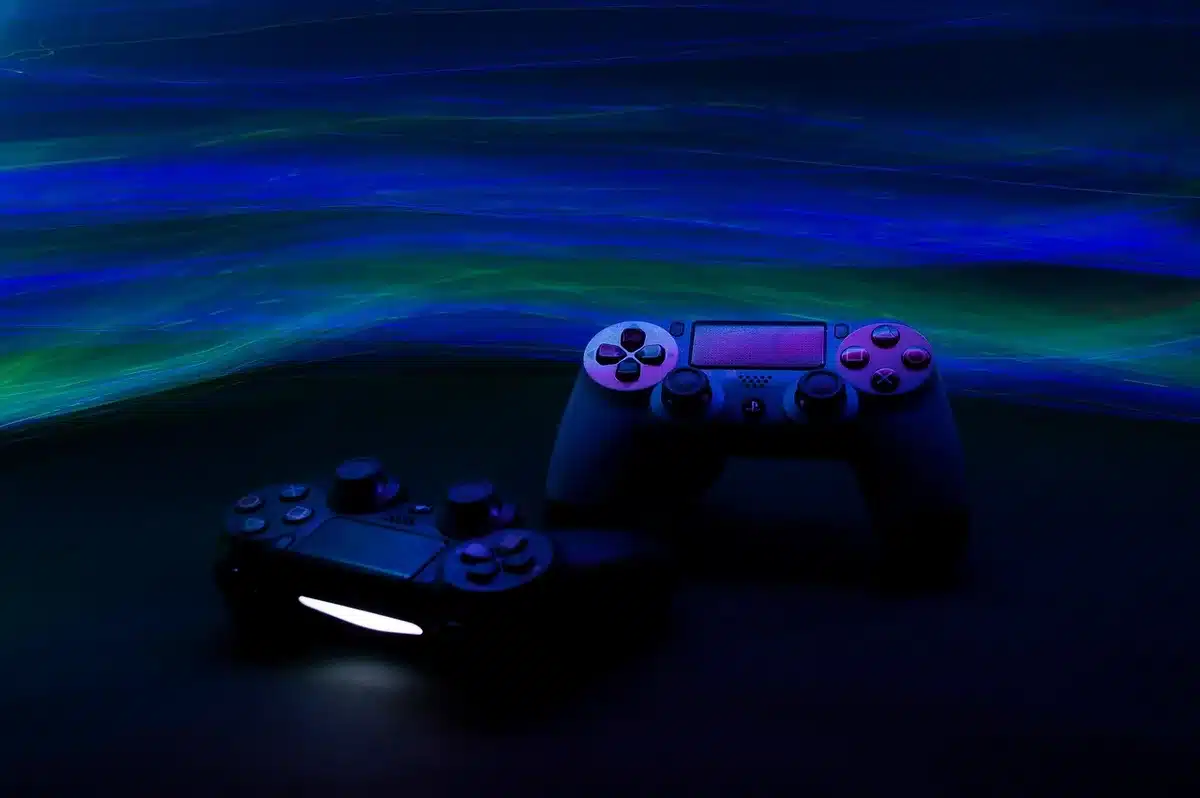Anonymous silhouettes of three gamers in a dim living room, backs to camera, looking at a blank TV showing a game launcher; hands on controllers, soft screen glow